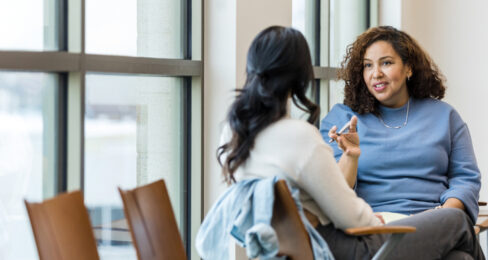 A female client sitting with her back to the camera while an advisor speaks to her.