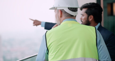 Two housing developers standing at a work site, discussing the project.