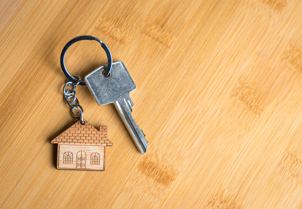 Keys to a new home with a wooden house keychain