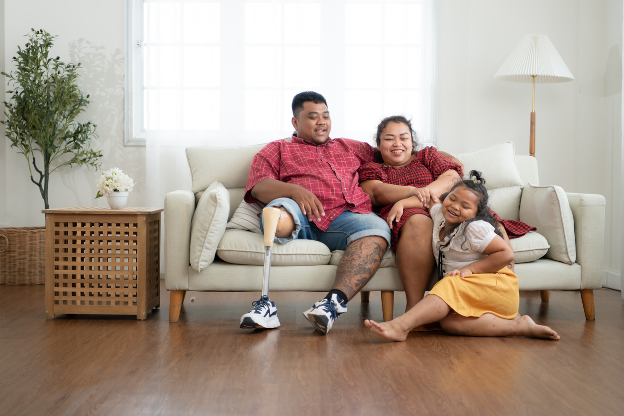 Parents and their young daughter relax on the couch at home.