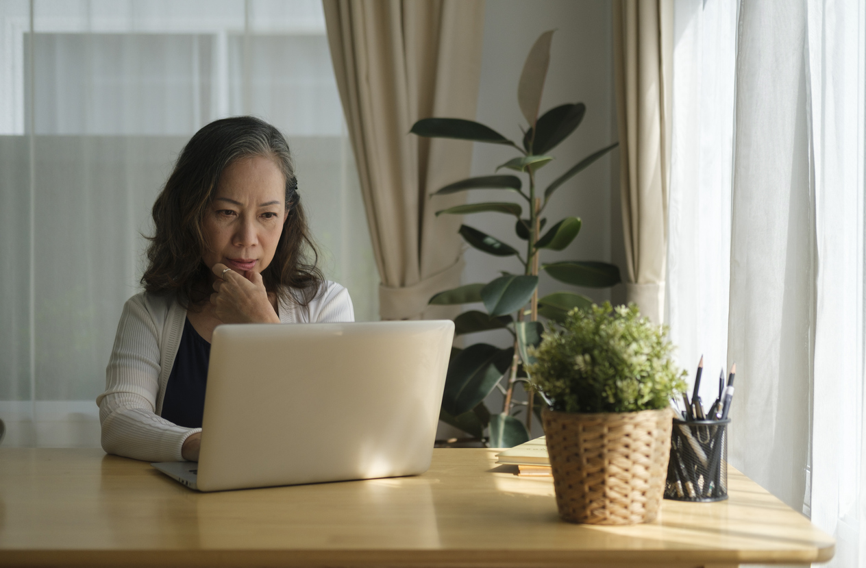 Woman reading online resources on her laptop computer.