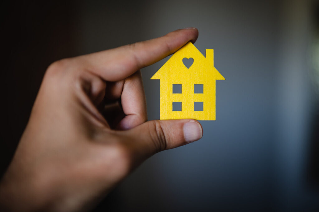 Cardboard house miniature in hands