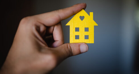 Cardboard house miniature in hands