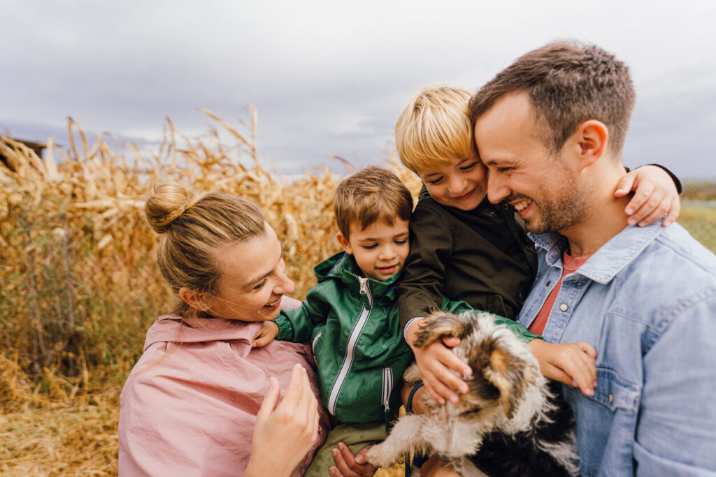 Photo of young family having a walk with their dog on a rainy autumn day